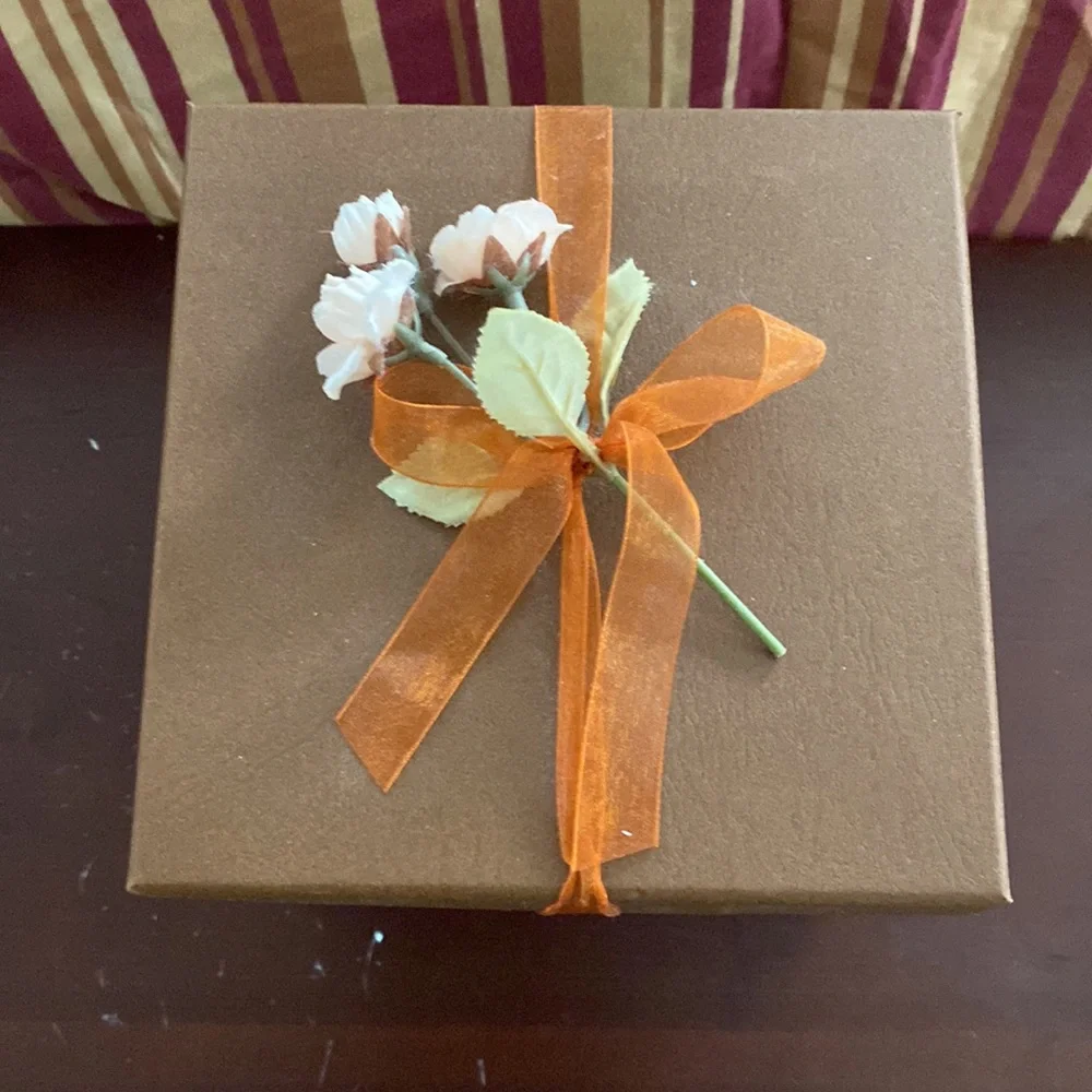 Pretty storage/gift box. Cardboard. Bronzish color with orange ribbon and flower